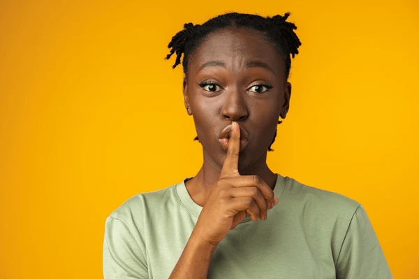 finger over mouth